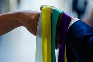 Mains d'un couple liées par des rubans colorés lors du rituel du Handfasting en cérémonie laïque